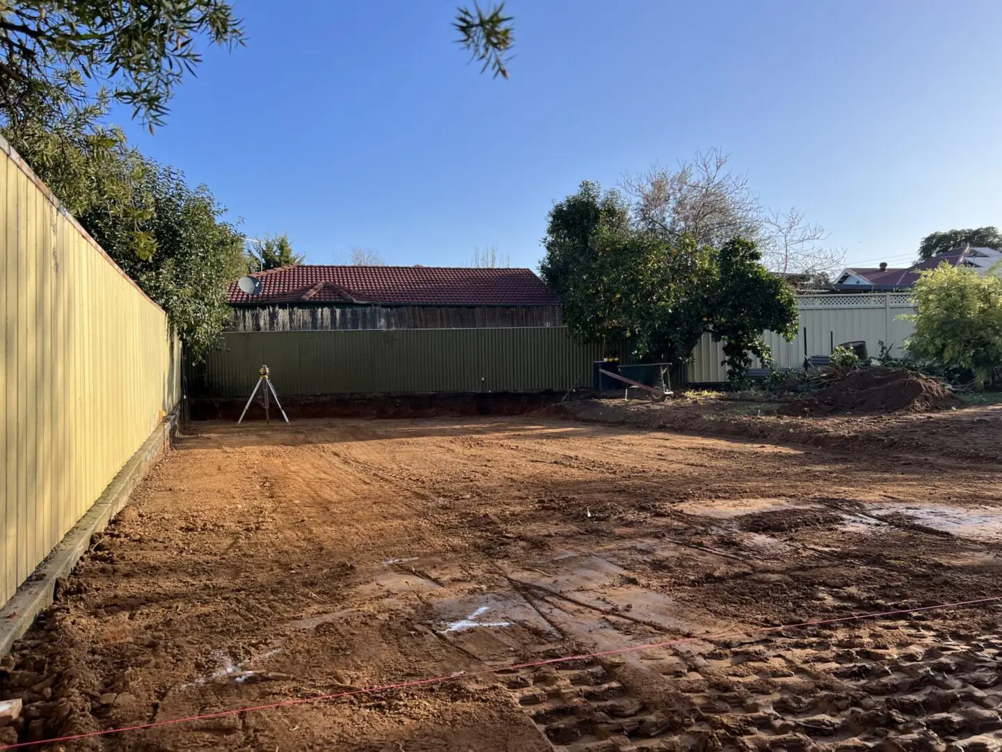 A lot of dirt in the ground with trees and buildings with land and site clearing